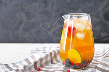 Jug of tasty cold tea on table