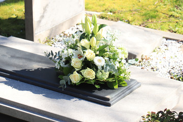 Funeral flowers on a tomb - 335428742