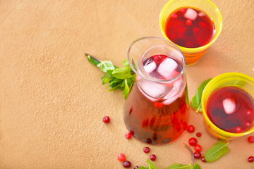 Jug and cups of tasty cold tea on color background