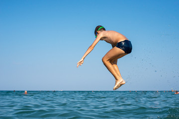 Executing water jumps. Boy flying in midair.