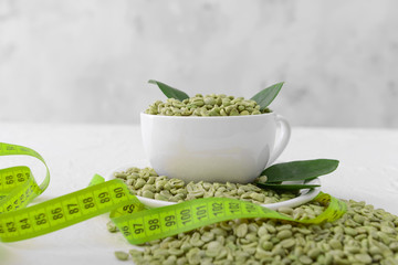 Green coffee beans and measuring tape on table