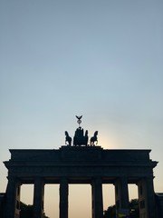 Fototapeta premium Brandenburg gate of Berlin with sun behind