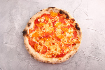 Pizza Margherita on stone background top view. Homemade Pizza Margarita with Tomatoes, Basil and Mozzarella Cheese.