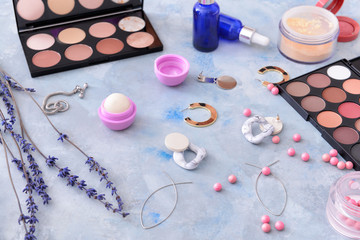 Makeup cosmetics with accessories on color background