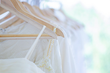 Many bridal dresses hang on the clothesline in studio wedding