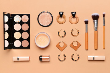 Makeup cosmetics with accessories on color background