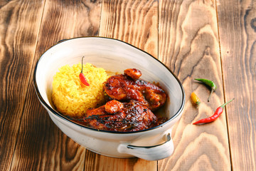 rice with beer chicken on wooden background with pepper in background