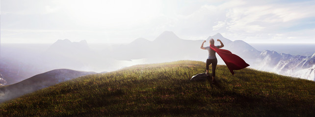 super woman flexing biceps on top of the mountain at sunrise