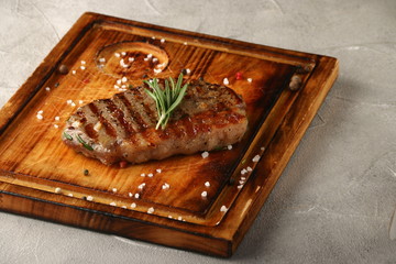 grilled steak on wood with rosemary closeup