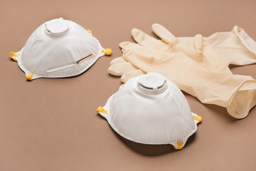 Medical masks and rubber gloves on color background