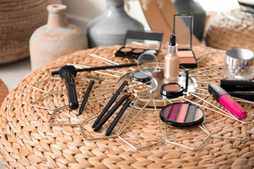 Set of decorative cosmetics of makeup artist on pouf in room
