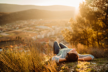 Optimistic young woman listening to music podcast stream over headphones,enjoying in nature at...