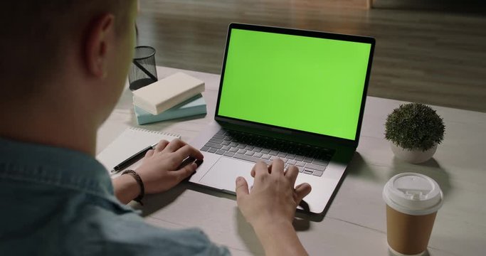 Close up shot of hands of a remote worker working on laptop computer with chroma key green screen, moving finger on trackpad - distance work, technology concept close up 4k template
