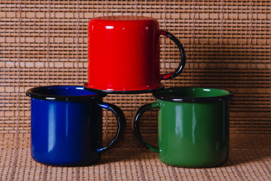 canecas de caf&eacute; coloridas empilhadas em fundo de madeira