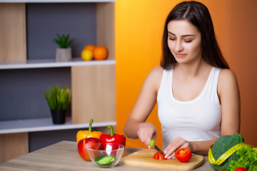 Young beautiful girl prepares a useful diet salad.