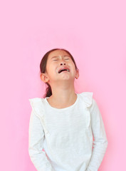 Portrait asian little girl crying isolated on pink background. Angry kid with sad expressions and screaming