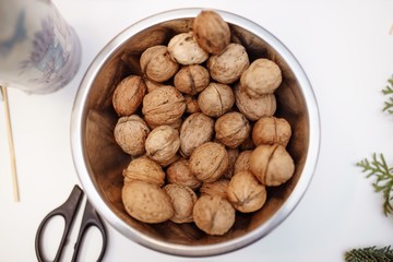 Walnuts in a chromed bucket on a white background. View from above