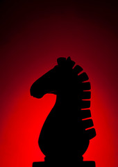 Wooden chess knight silhouette with red background