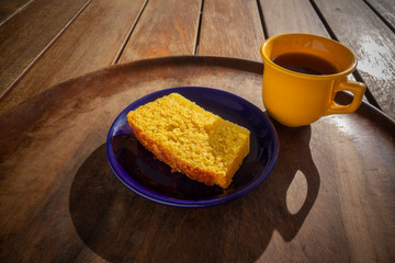 Delicious slice of corn cake with guava syrup accompanied with a cup of coffee