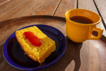 Delicious slice of corn cake with guava syrup accompanied with a cup of coffee