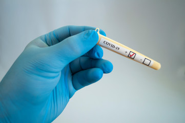 Test tube with coronavirus tests in the hand of a medical professional