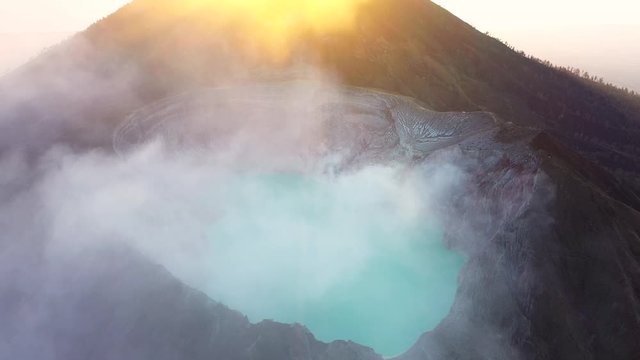 View from above, stunning aerial view of the Ijen volcano with the turquoise-coloured acidic crater lake during a beautiful sunrise. East Java, Indonesia.