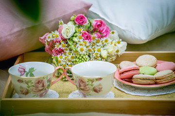 Small table with two cups of tea and cookies on a picnic in nature