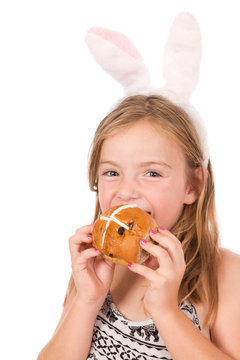 An Eight Year Old Girl Eating A Hot Cross Bun For Easter.