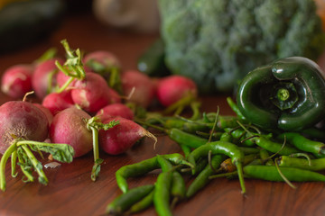 Close up of some chili peppers and some other vegetables on a wooden table