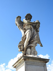 Fototapeta na wymiar Escultura de angel sobre el puente de San Angelo en Roma, Italia