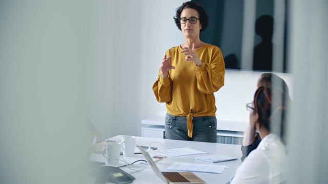 Manager talking with colleagues in the meeting room. Business professionals having a meeting in the boardroom.
