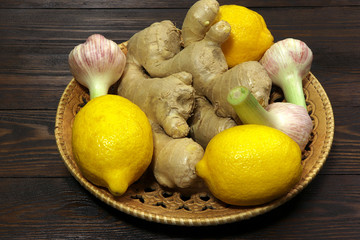 Ginger, lemon and garlic on a wooden tray. Helthy food. Vitamins.