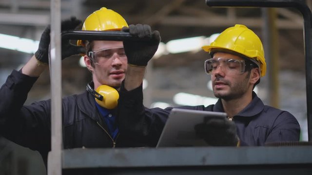 Front view of two technicians or factory workers try to learn how to operate and prepare to solve the problem of the machine.