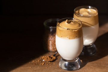 Iced Dalgona coffee in a glass on a dark background. Korean trend drink