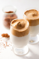 Iced Dalgona coffee in a glass on a white table. Korean trend drink