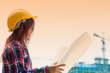 Asian engineer woman look Successful with her job. Asian architect looking at the distance to lead to success with yellow helmet and jean shirt. Concept Engineer and business work, duplicate photo.