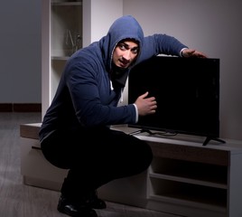 Burglar thief stealing tv from apartment house