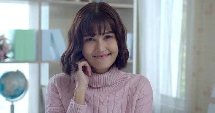 Young asian woman smile with shy and looking to camera
