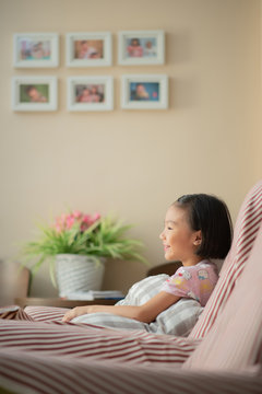 Asian child (girl) at home during lockdown, watching TV