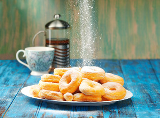 Homemade donuts with tea in the afternoon a wooden blue background.