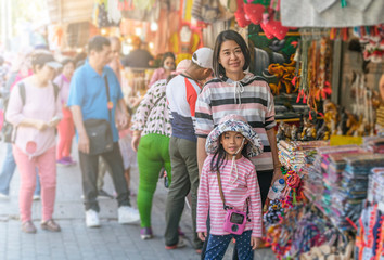 tourist mother and daughter at street market