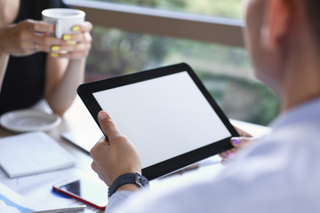 Businessman holding tablet in hand in cafe white screen