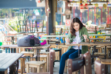 Fototapeta premium Happy charming girl sitting in modern art cafe reading book