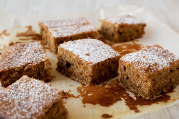Homemade Tasty Applesauce Cake on a white plate on a white wooden surface, side view. Close-up.