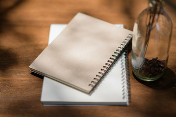 Notebook and pen placed on a wooden table.working at home concept .