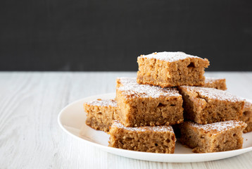 Homemade Applesauce Cake on a white plate, side view. Copy space.