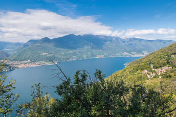 Fototapeta na wymiar Big european lake in the mountains seen from above. Lake Maggiore, Italy, with the city of Cannobio on the left. Amazing summer landscape