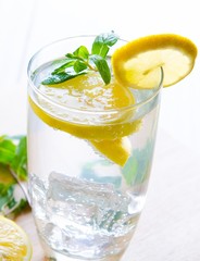 Glasss of mojito with lemon and drinking straw