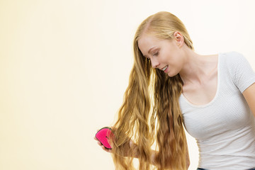Fototapeta premium Blonde girl brushing her long hair