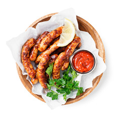Delicious homemade baked sausages in a wooden plate isolated on white background